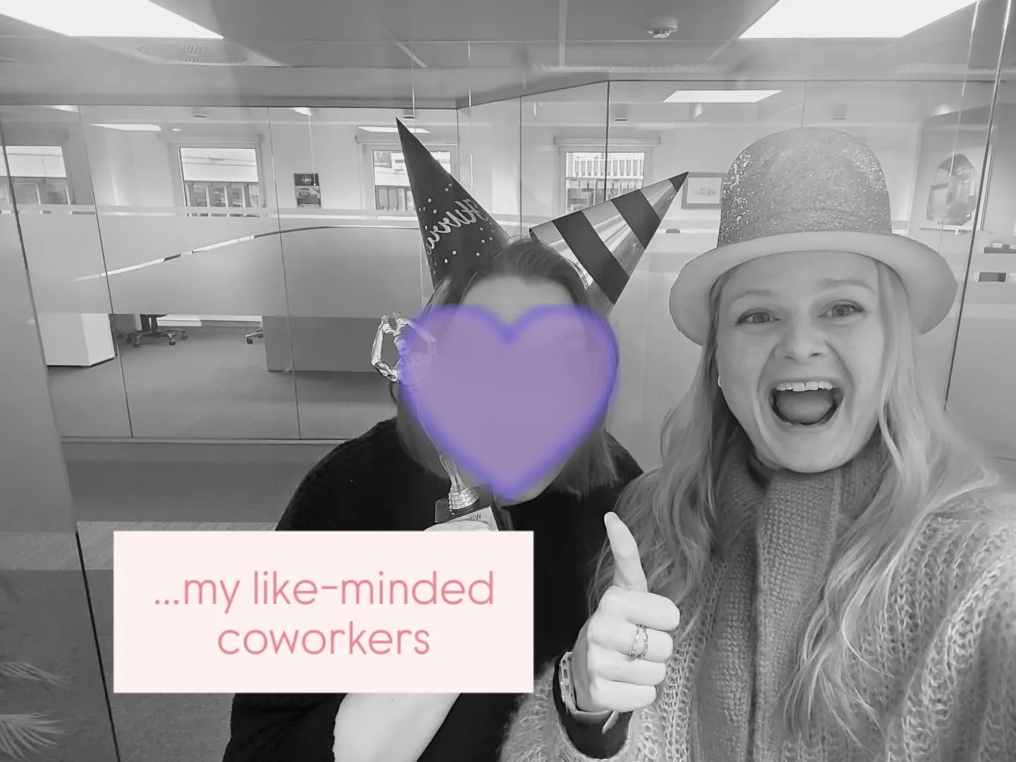 Tine og en kollega med festhatter på kontoret. Kollegaens ansikt er dekket av et lilla hjerte. Over bildet står det «…my like-minded coworkers».